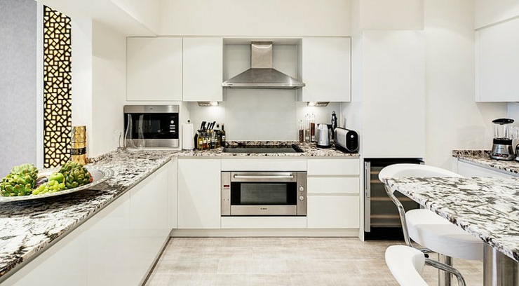 Cuisine design tout en blanc de cet appartement avec vue cuisine en marbre blanc et marbre gris