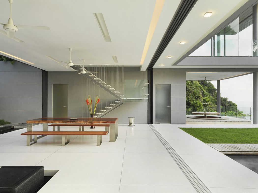 Coin salle à manger avec une grande table en bois exotique et deux simples bancs en bois massif salle à manger séjour espaces communs villa