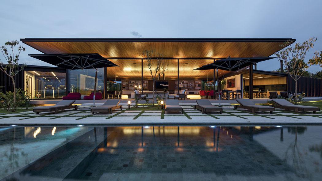 La maison contemporaine d’architecte vue de nuit depuis la terrasse avec la piscine extérieure Piscine extérieur résidence de standing maison d'archi