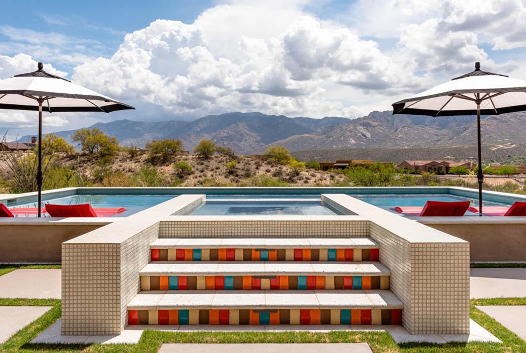 Une piscine décorée avec des chaises longues rouges semi émergées dans l’eau piscine hors sol maison familiale de luxe arizona