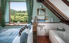 Une solution intéressante pour aménager une chambre avec salle de bains sous le plafond chambre rustique aménagée sous le toit