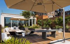 Maison de ville à la belle terrasse en bois joliment ombragée par un parasol déporté joli parasol excentré fratello terrasse