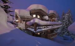 Le chalet de ski de haut standing situé à Courchevel éclairé à la nuit tombée beau chalet de vacances ski Courchevel