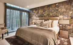 La suite des maitres est décorée avec des pierres locales spécialement taillées pour apporter une touche rustique à l’ambiance chambre moderne et rustique mur en pierre villa de luxe