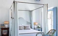 L’une des nombreuses chambres à coucher de cette belle propriété de haut standing lit a baldaquin maison Grèce e blanc et bleu