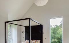Une des chambres à coucher situées à l’étage de cette belle maison neuve à la campagne mobilier minimaliste ameublement chambre moderne