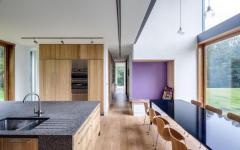 Une grande cuisine contemporaine aménagée d’une longue table pour toute la famille cuisine moderne minimaliste mobilier en bois massif