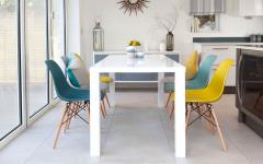 Petite salle à manger en blanc meublée des chaises Eames de différentes couleurs pastel salle à manger chaise eames