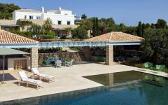 La seconde terrasse de cette magnifique maison méditerranéenne avec une énorme piscine et belle vue sur la côte de l’île belle demeure maison méditerranéenne grèce