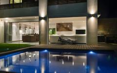 La piscine et la transformation de la pièce de vie principale à la tombée de la nuit grande piscine luxe design outdoor