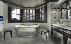La salle de bains attenante où on peut admirer le marbre et la magnifique vue sur les arbres enneigés salle de bains luxe chic avec vue montagne alpes