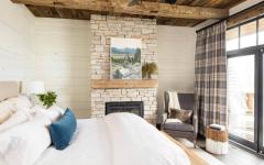 La suite parentale située à l’étage possède son propre balcon avec une jolie vue sur un paysage naturel chambre intérieur rustique maison secondaire campagne montagne