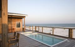 La terrasse offre une vue imprenable sur la plage et la mer situées à deux pas de la villa terrasse en bois piscine petite au jacuzzi