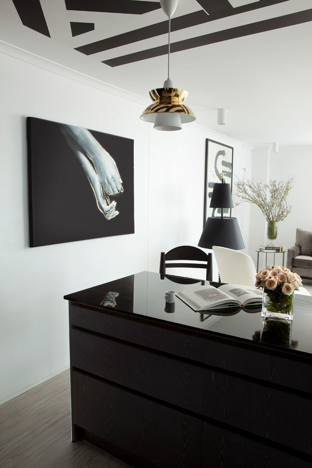 Un comptoir large faisant office de plan de travail et table à manger pièce principale en noir et blanc design chic