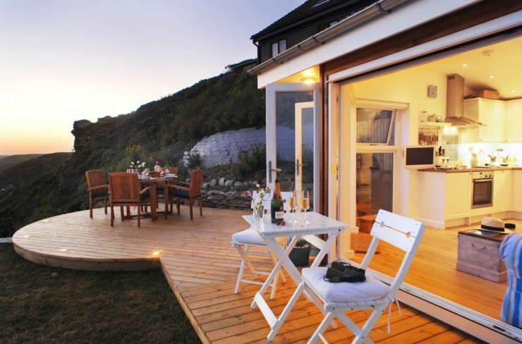 Le petit cottage illuminée dans lors du coucher du soleil terrasse cottage côtier