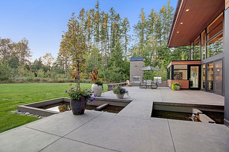 Grande terrasse donnant sur un jardin vert et entretenu espaces outdoor maison d'architecte