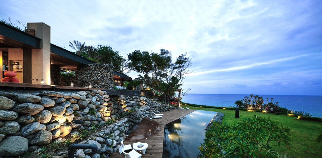La piscine à débordement, la grande pelouse se trouvent sur le plus bas niveau du terrain location touristique de luxe villa de rêve