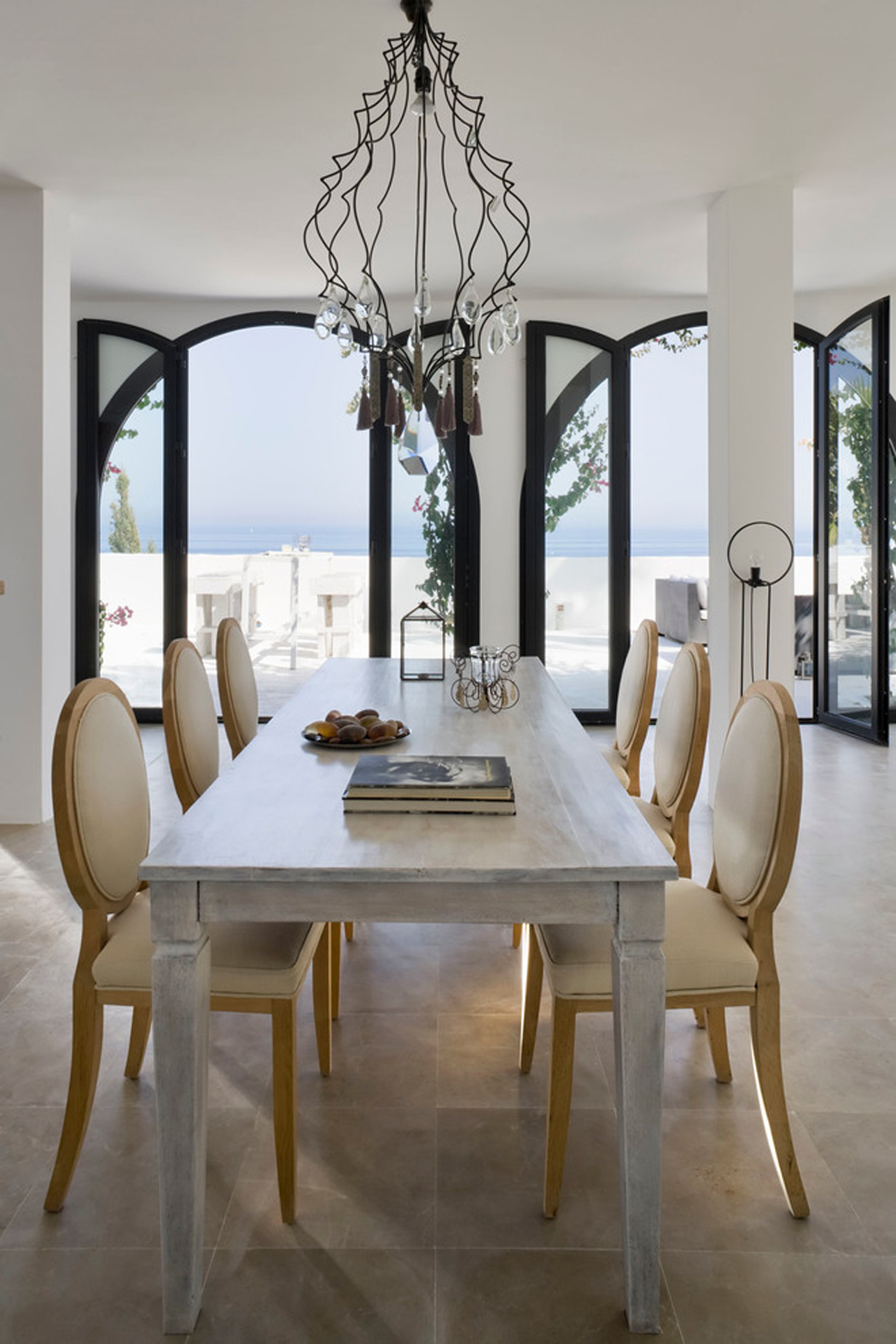 La salle à manger avec une table pour huit sur un fond de paysage paradisiaque salle à manger avec vue sur la mer