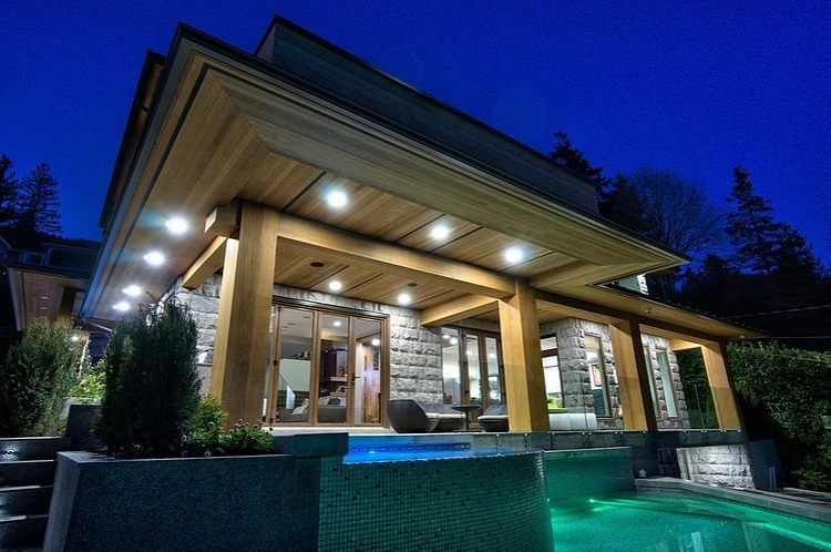 Grande piscine extérieur dans le jardin arrière vue de nuit la maison éclairée